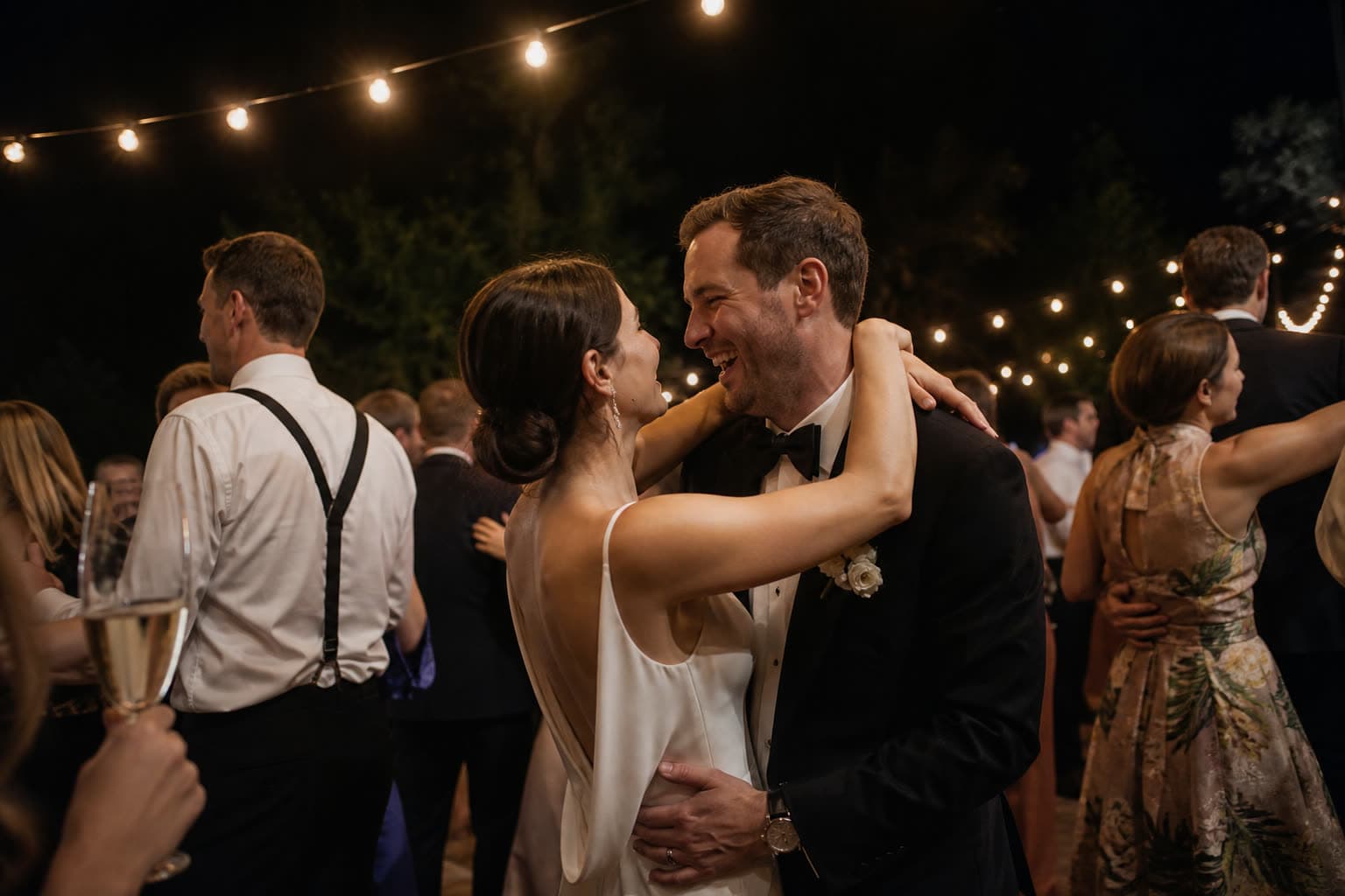 Couple dancing under string lights at their wedding